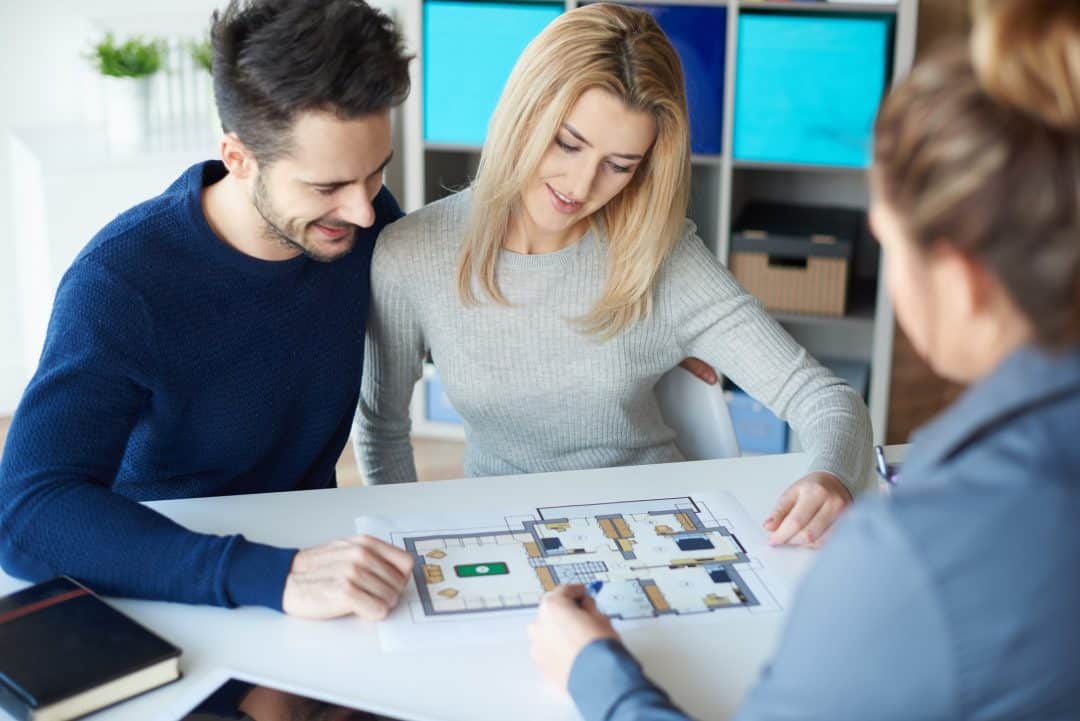pareja en reunión con una agente inmobiliaria