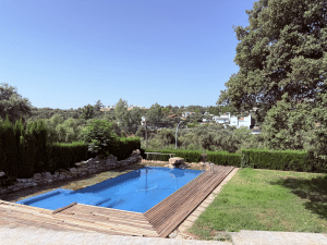 Piscina azul de chalet con área de césped y vistas despejadas a la Sierra Norte en Las Pajanosas, Guillena.