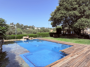 Piscina privada de diseño con zona de madera y césped en Chalet independiente en Las Pajanosas, Guillena.