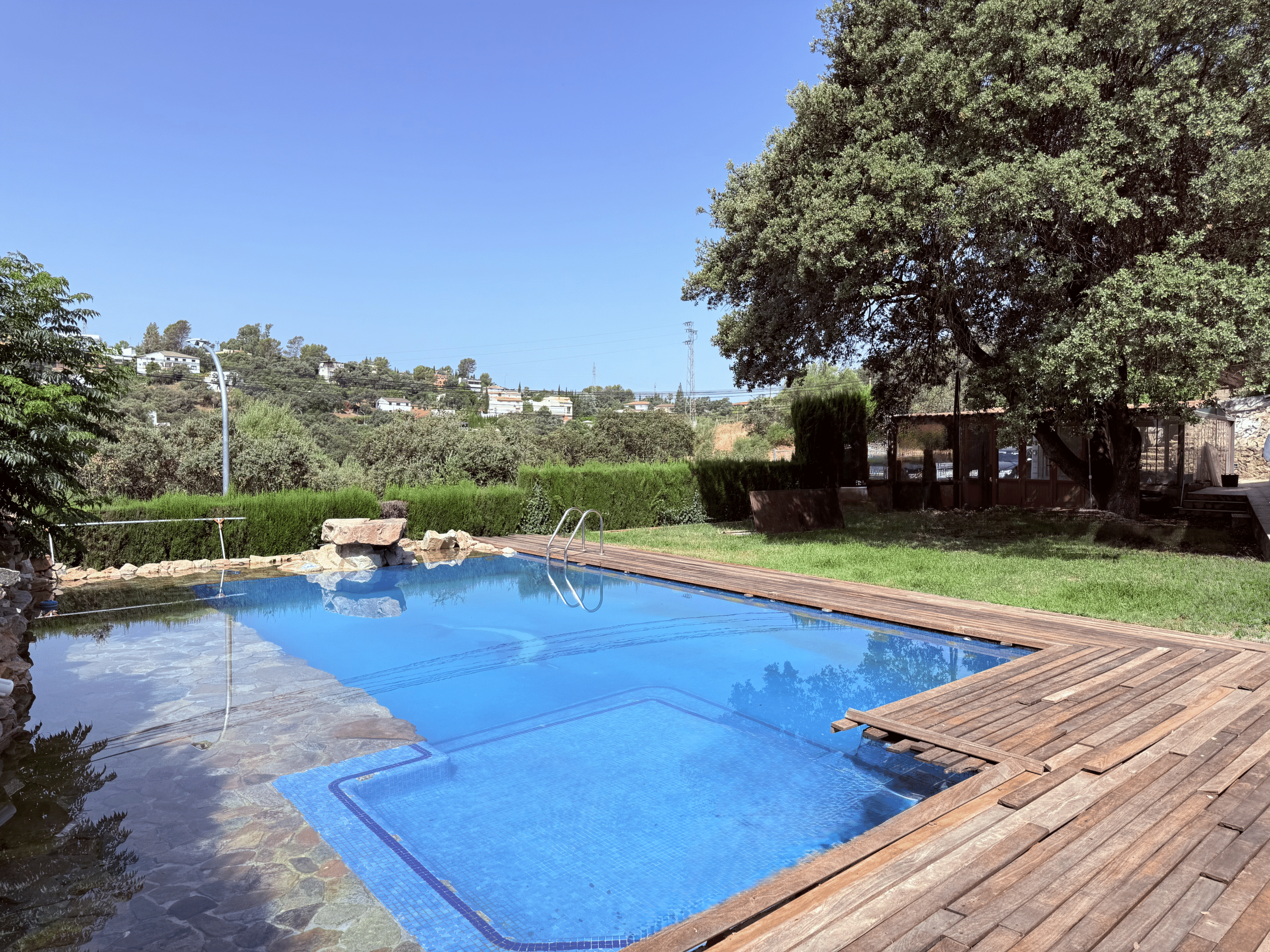 Piscina privada de diseño con zona de madera y césped en Chalet independiente en Las Pajanosas, Guillena.