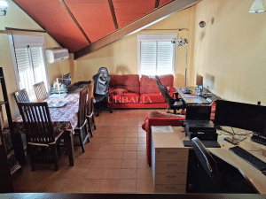 Buhardilla multifuncional con zona de teletrabajo, ocio y comedor en chalet en Alcalá del Río.