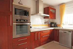Cocina completa con lavavajillas integrado, horno y ventana en chalet adosado en Alcalá del Río