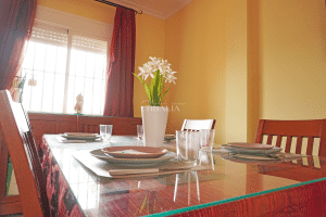 Comedor con mesa de cristal, sillas de madera y ventana luminosa en chalet en Alcalá del Río