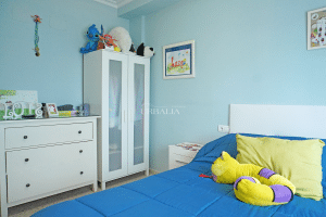 Dormitorio individual con cama armario y cómoda en tonos azules en Alcalá del Río.