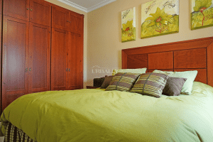 Dormitorio principal con cama doble y gran armario empotrado de madera en chalet adosado en Alcalá del Río.