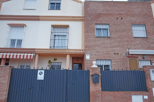 Fachada de chalet adosado en venta en Alcalá del Río con rejas y garaje incluido