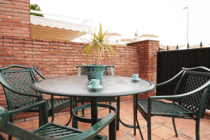 Patio delantero amueblado con mesa y sillas para café en chalet adosado en Alcalá del Río