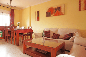 Salón-comedor amplio con zona de sofás y mesa de comedor en chalet adosado en Alcalá del Río