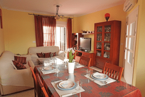 Salón Comedor completo con área de sofás, zona de TV y mesa de comedor en chalet en Alcalá del Río.