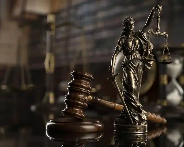 La Dama de la Justicia y el Mazo Una estatua de la Dama de la Justicia junto a un mazo de juez de madera.